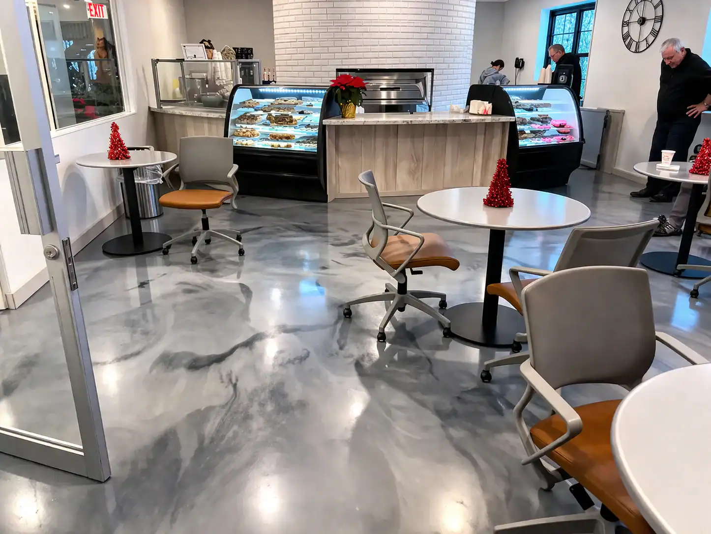 Modern NY bakery features round tables, display cases, and chic epoxy floors by Bohemia contractors.